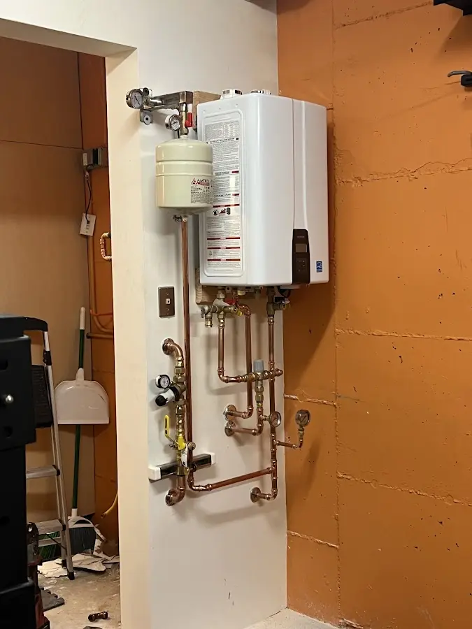 Plumbing technician inspecting water heater connections in Spring Lake
